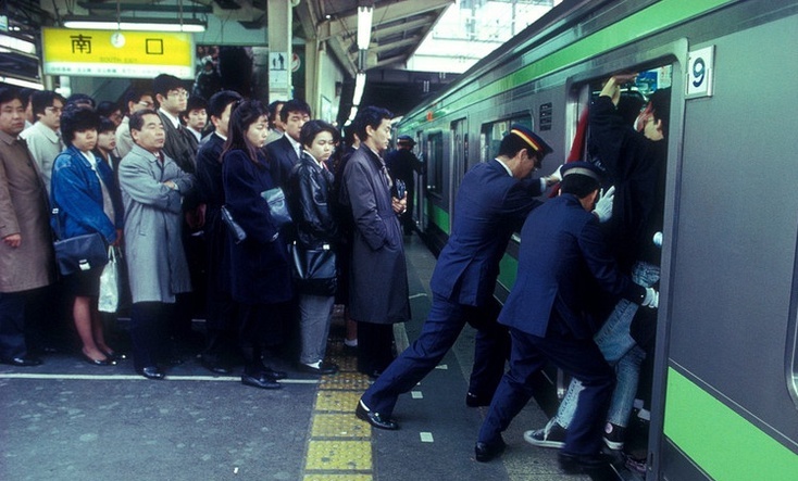 pushing passengers on to rush hour train tokyo