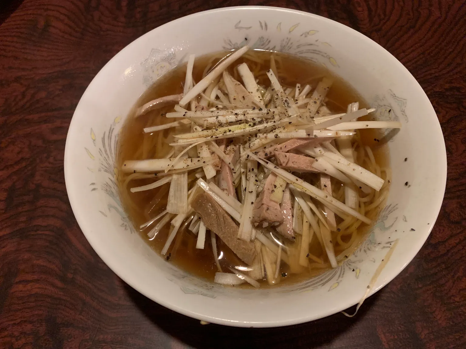 細切りのねぎとチャーシューをのせた塩ラーメン。