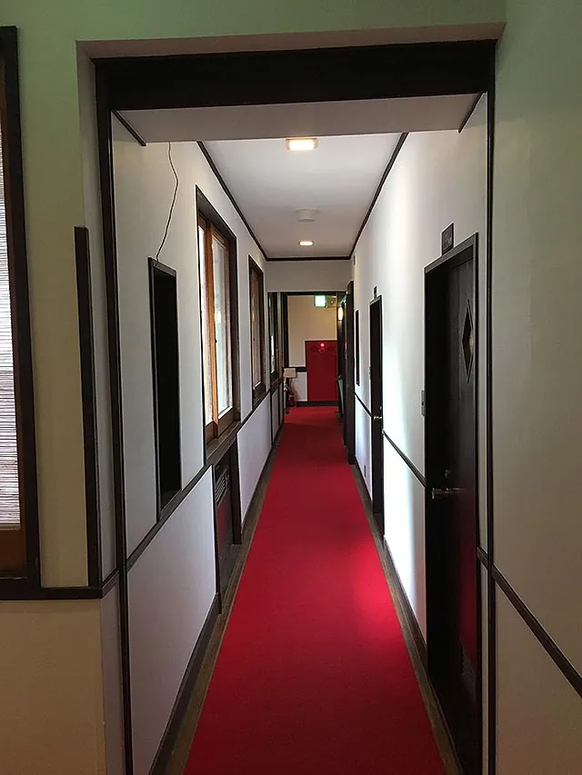 A long red-carpeted corridor running through the inn.