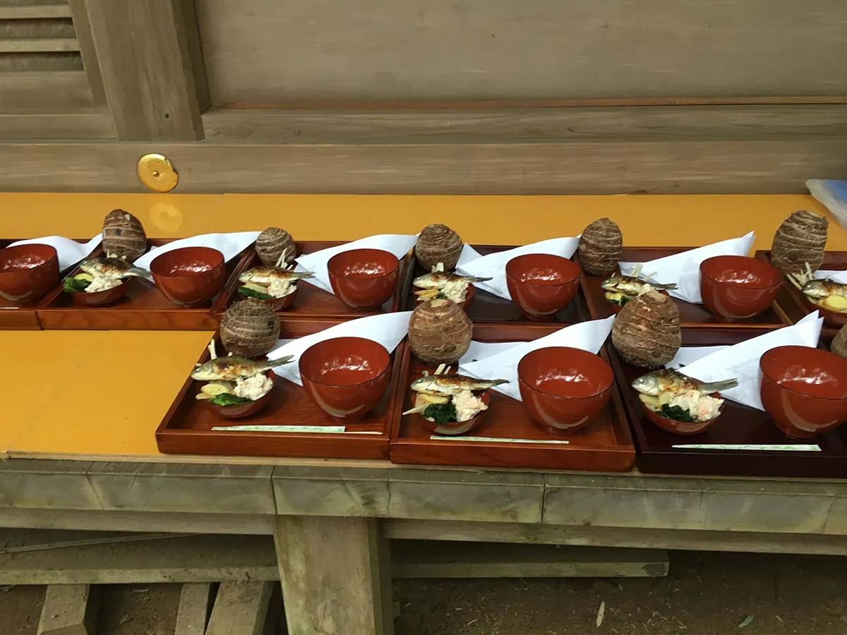 祭りのために長い台に並べられた、朱塗りのお膳とお椀。